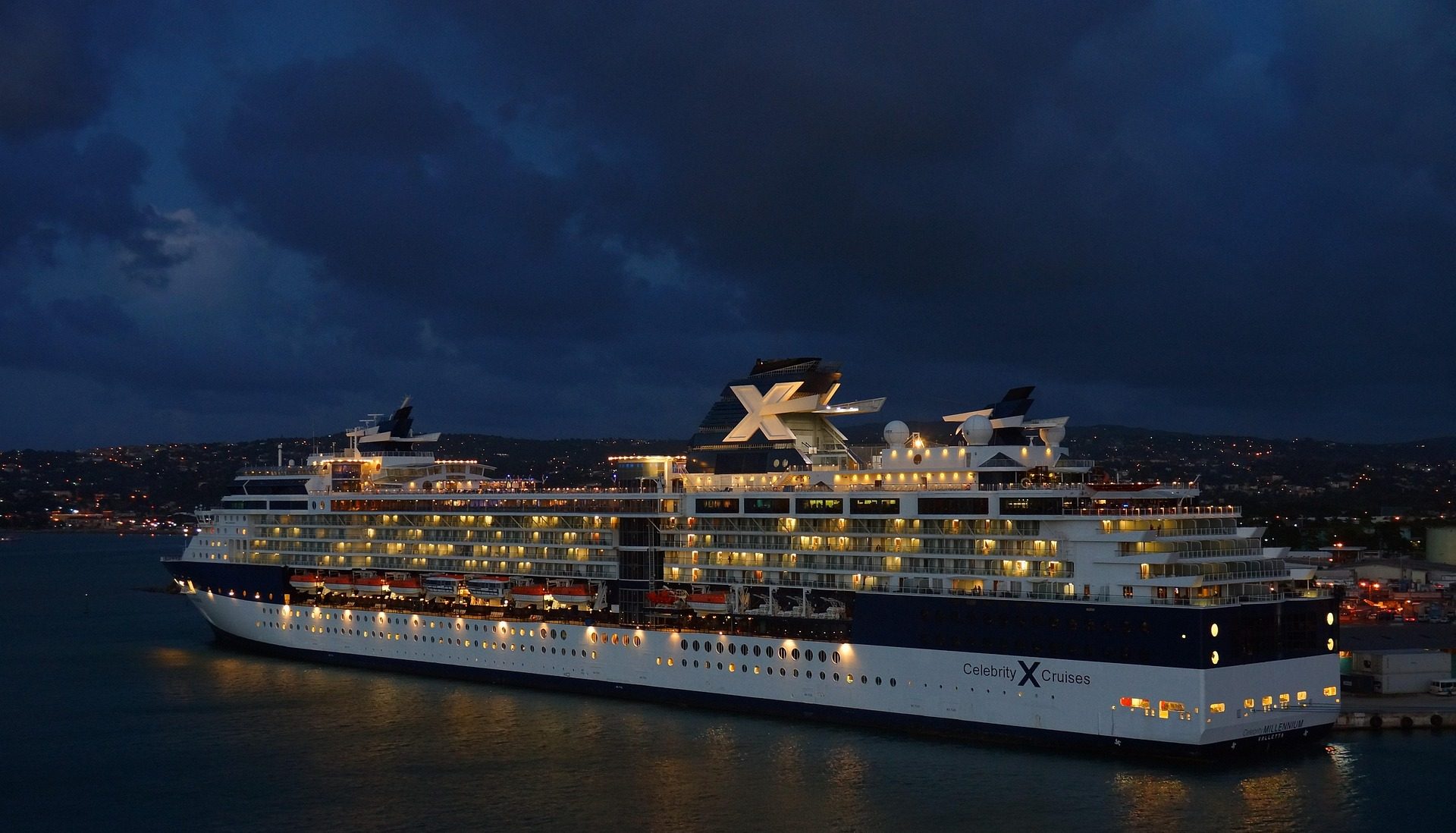 galveston cruise ship gangway A brightly lit cruise ship docked at night under a cloudy sky.