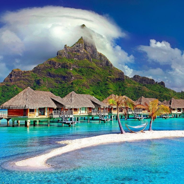 Exclusive luxury travel experiences worldwide Luxury traveler relaxing at an overwater bungalow resort