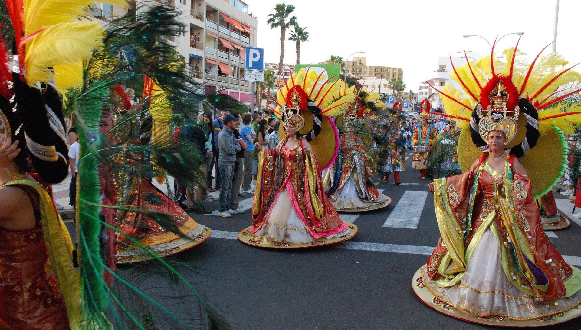 Flight and Hotel Deals Colorful dancers in elaborate costumes perform during a festive parade.