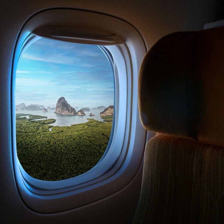 Travel Group Trips A globe, eyeglasses, a passport, and a compass on a wooden surface.