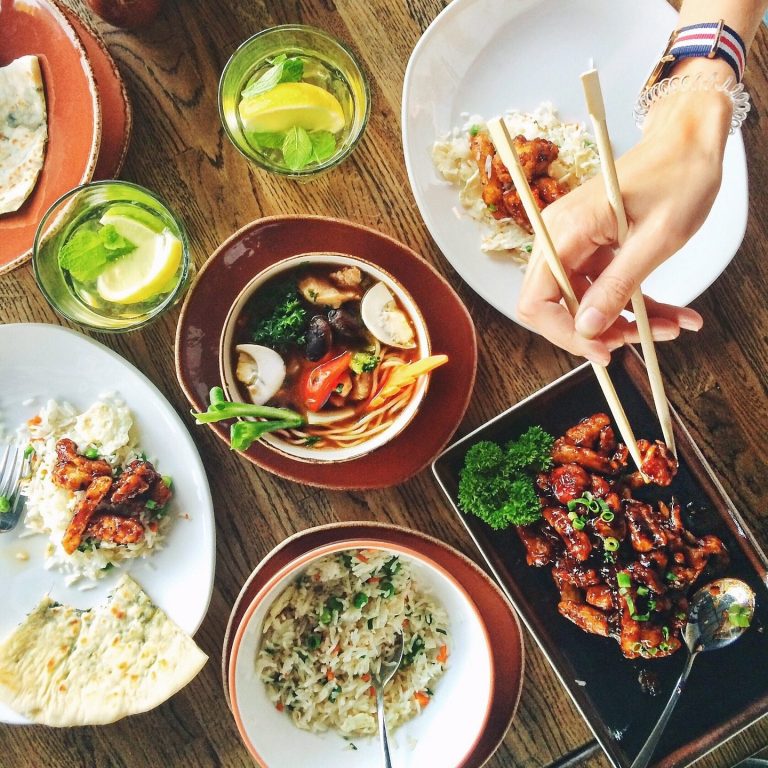 Culinary Vacation A variety of Asian dishes served with chopsticks and drinks, showcasing vibrant colors and textures.