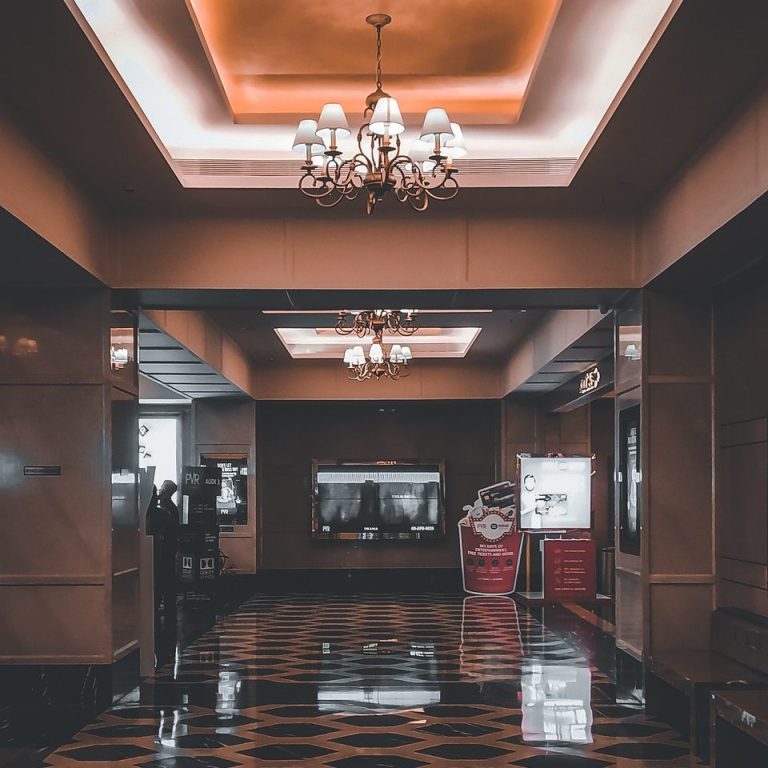 Traveler reviewing hotel options on laptop with travel itinerary and suitcase nearby