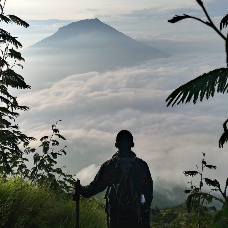 Independent solo vacations for personal discovery Solo traveler hiking to a volcano at sunrise