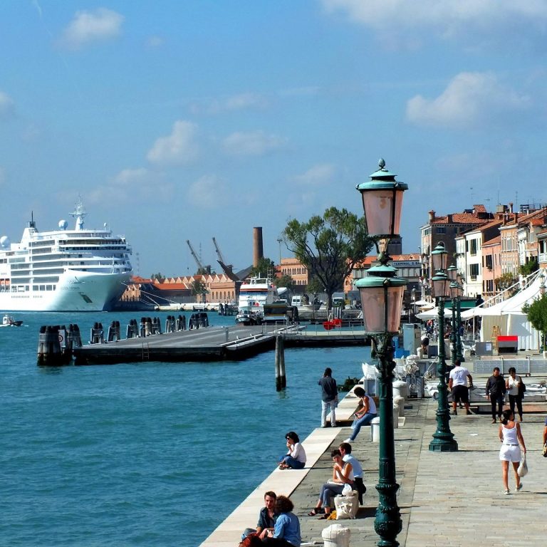 Boarding a cruise liner as it departs from a palm-lined tropical port beginning a dream vacation full of scenic travel adventures 